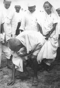 Gandhiji at Dandi picking up salt in a protest against British Government. 